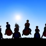 Silhouettes of Children Playing on Balls and Copy Space Above